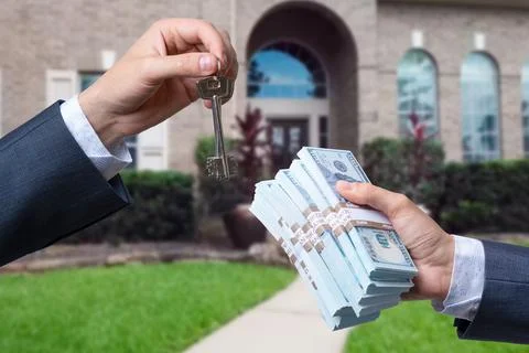 Man Handing a man Thousands of Dollars For Keys in Front of House. Stock Photos