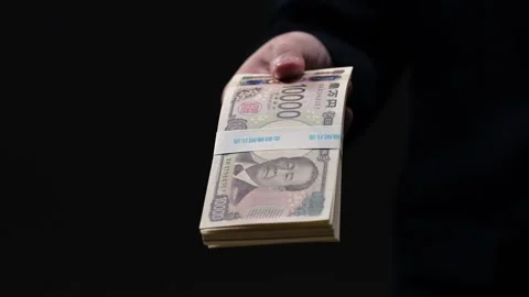 Man handing over a bundle of new Japanese banknotes as a bribe Stock Footage 336765761
