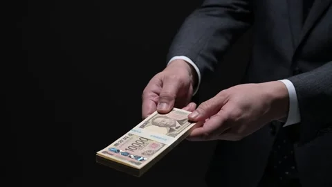 Man handing over a bundle of new banknotes in the dark Stock Footage 336765813