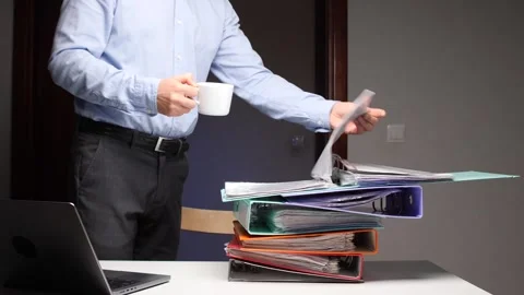 Man handling stack of binders, managing paperwork overload Stock Footage 322910666
