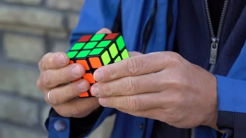Man hands accelerated trying to solve the Rubik's cube Stock Footage 96144471
