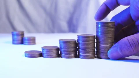 A man hand's adds coins to a stack. Concept of global economic crisis Stock Footage 287740372