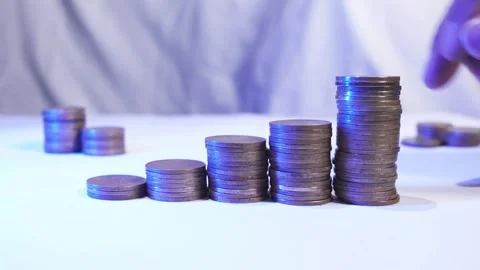 A man hand's adds coins to a stack Video stock 287740373