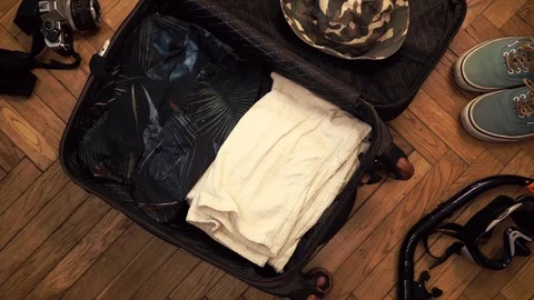 Man hands are fast packing suitcase for a journey. Man dreams about travell Stock Footage 113746182