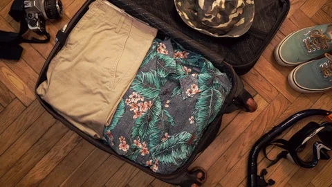 Man hands are packing suitcase for a journey. Travel blogger. Summer clothing Stock Footage 113746143