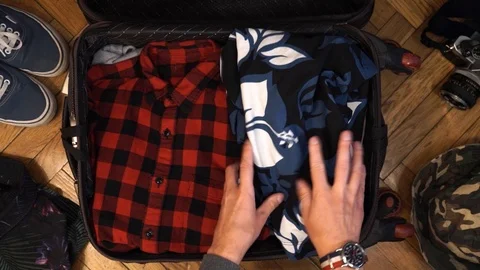 Man hands are packing suitcase for a journey. Man dreams about travell. Summer Stock Footage 113746539