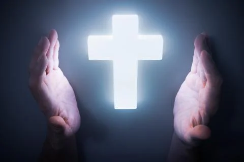 Man hands around shining light from glowing crucifix. Religion concept. Foto stock
