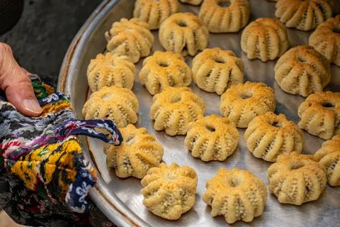 Man hands baking eid kahk in arabian oven Stock Photos