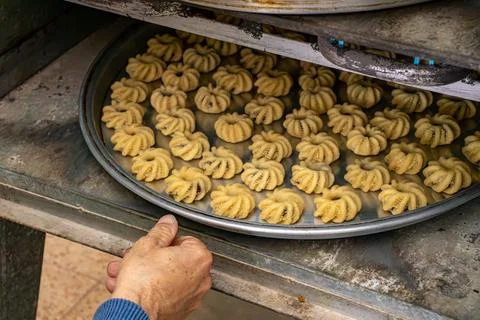 Man hands baking eid kahk in arabian oven Stock Photos