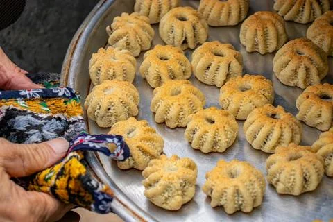 Man hands baking eid kahk in arabian oven Stock Photos