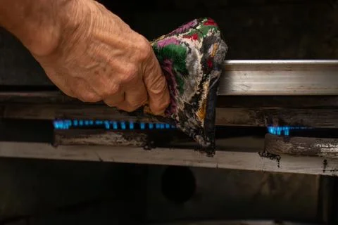 Man hands baking eid kahk in arabian oven Stock Photos