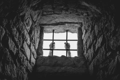 Man hands behind bars Stock Photos