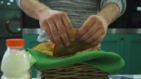 Man hands break cheburek in half above basket on table Stock Footage 195446058