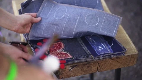 Man hands choosing cloth patch from denim pile variety Stock Footage 76538592
