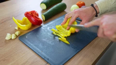 Man hands chopping fresh yellow bell pepper on a cutting board Stock Footage 335652111