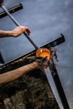 Man Hands Closeup Working on a Blown Glass Piece Foto stock