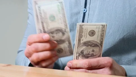 Man hands counting dollar banknotes sitting in room at table. Banking and Stock-Footage 336260739