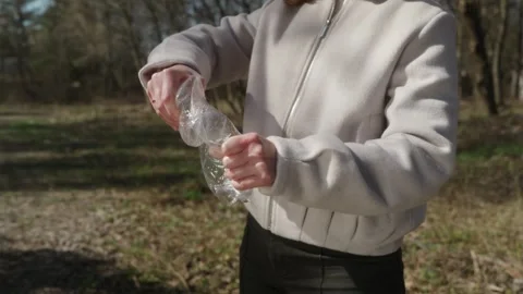 Man hands crushing plastic bottle for volume reduction and recycling Stock Footage 333118470