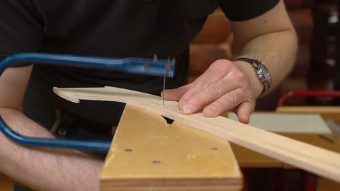 Man hands cut outdated jetliner model with blue fretsaw Stock Footage 126895677