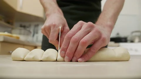 Man hands cut raw dough on the table, handmade cooking Stock Footage 222742911