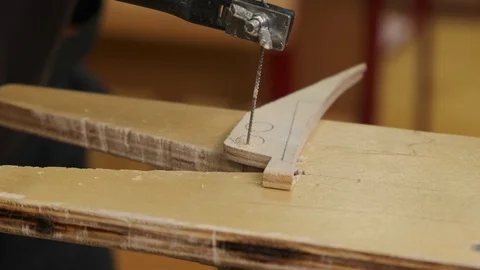 Man hands cut small circle from brown plywood with fretsaw Stock Footage 127375426