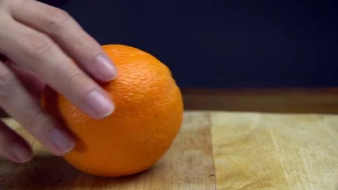 Man Hands Cutting Orange with Knife on Chopping Board, Slider Stock Footage 76521203
