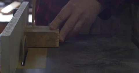Man hands cutting wood with a machine. Circular table saw cutting wood in Stock Footage 130463656