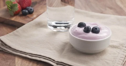 Man hands decorating yogurt with blueberries Stock Footage 75035313