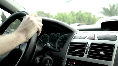 Man hands driver on steering wheel of a modern car on with street background. Stock-Footage 336268426