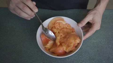 Man hands eats papaya from a plate with a spoon top view HLG3, BT.2020 Stock Footage 231174502