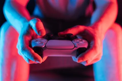 Man hands with game controller in neon light, front view Stock Photos