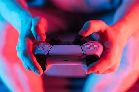 Man hands with game controller in neon light, front view Stock Photos