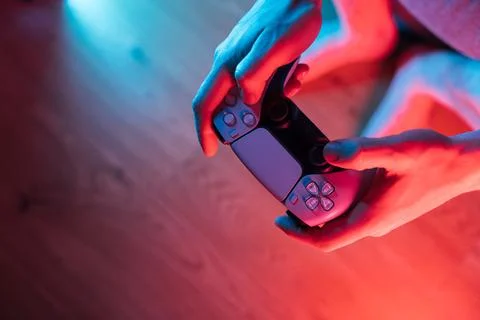 Man hands with game controller in neon light, top view Stock Photos