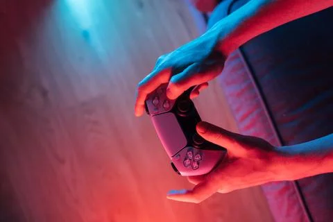 Man hands with game controller in neon light, top view Stock Photos
