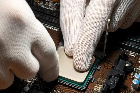 Man hands in gloves replacing processor on the computer motherboard 写真素材