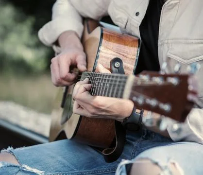 Man hands on the guitar strings close up image Stock Photos