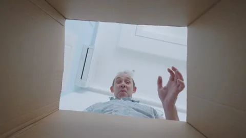 Man with hands on head, screaming in surprise while looking into a box Stock Footage 294896152