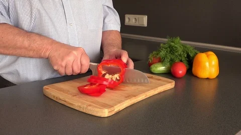 Man hands hold and cut sweet red pepper on cutting board Stock Footage 108605644