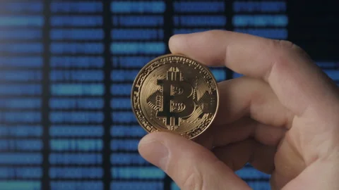 Man hands hold gold Bitcoin on binary code background. mining and trading Stock Footage 86279461