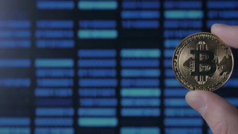 Man hands hold gold Bitcoin on binary code background. mining and trading Stock Footage 86280225