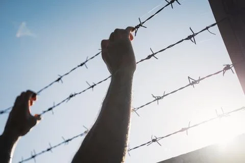 Man hands holding barbed wire. Refugee, Freedom Concept. Stock Photos