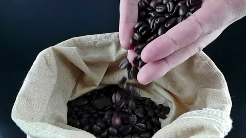 Man hands holding coffee beans in canvas sack and some falling down Stock Footage 80047167
