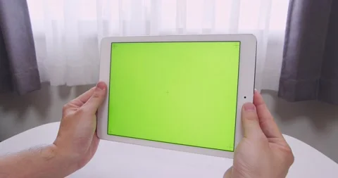 Man hands holding Green Screen (chroma key) smart tablet in his room Stock Footage 153011952