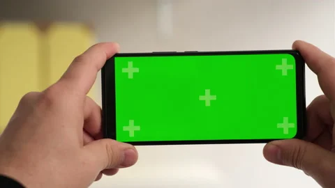 Man hands holding green screen chroma key smartphone in office without keying Stock-Footage 237574497