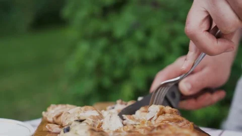 Man hands holding knife and fork, cutting fresh campfire steak outdoors Stock Footage 111648972