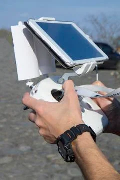 Man hands holding remote controller using tablet for drones flying. Stock Photos