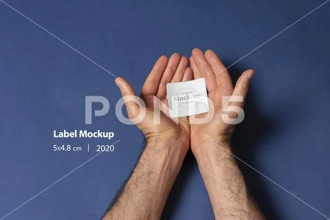 A man hands holding a small label inside palm mock-up series PSD Template