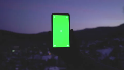 Man hands holding smartphone with greenscreen chromakey on the evening night Stock Footage 150584868