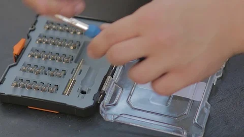 Man hands install screw bit on handle, screwdriver set on the background. Video stock 76942172