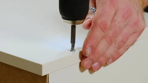 Man hands install screw into wall hole with electric screwdriver Video stock 304397310